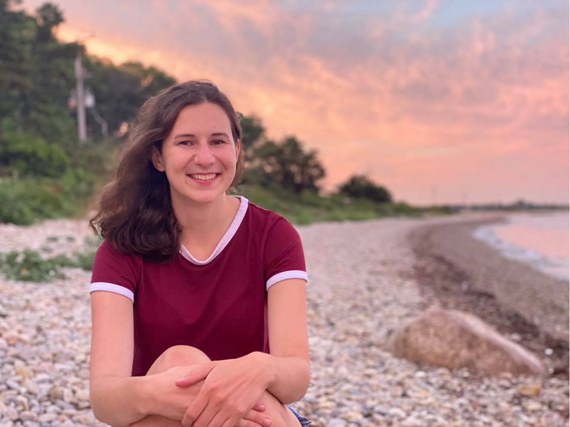 Photo of Jennifer Vaccaro in a red shirt on a stony beach